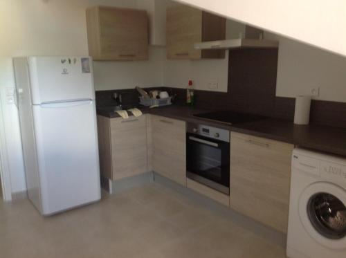 een keuken met een witte koelkast en een vaatwasser bij Le Marina 2 in Propriano