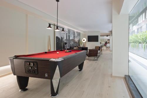 a pool table in a living room with a red pool at Aparthotel Bcn Montjuic in Barcelona