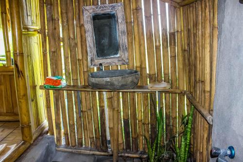 a wooden bathroom with a sink on a wooden wall at Echo Alam Nusa Lodge in Nusa Penida