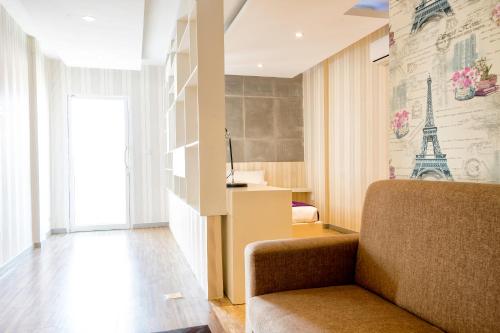 a room with a chair and a wall with the eiffel tower at White Residence Hotel & Apartment in Phnom Penh