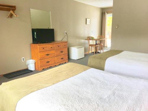 a hotel room with two beds and a television at The Spirit Rock Outpost & Lodge in Wiarton