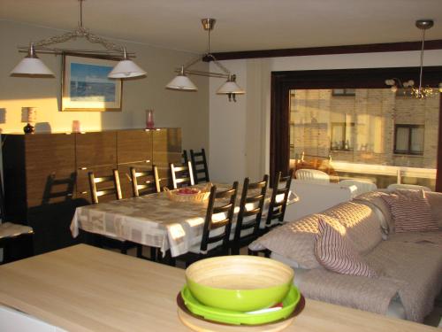 uma cozinha e sala de jantar com uma mesa e um sofá em Residentie Beverly em Oostduinkerke