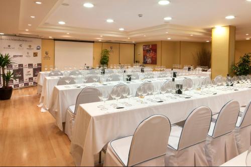 a large banquet hall with white tables and chairs at Hotel Gran Via in Logroño