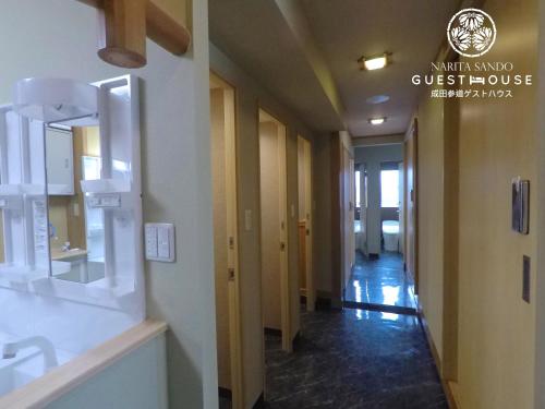 a hallway of a building with a hallwayngth at Narita Sando Guesthouse in Narita