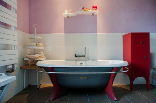 a bathroom with a bath tub and a red cabinet at Chateau Le Colombier in Brévands