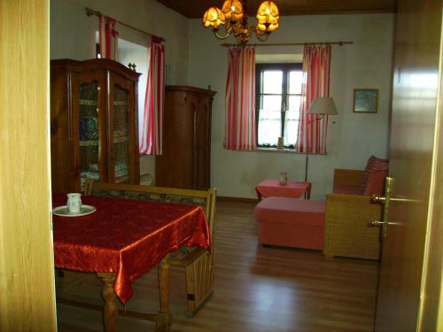 a living room with a table with a red table cloth at Gästehaus Brückler in Jennersdorf