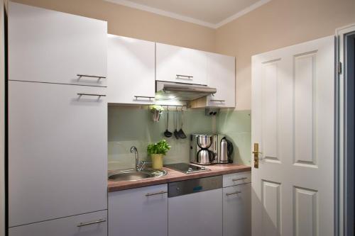 a kitchen with white cabinets and a sink at Guest house Villa Fritz in Potsdam