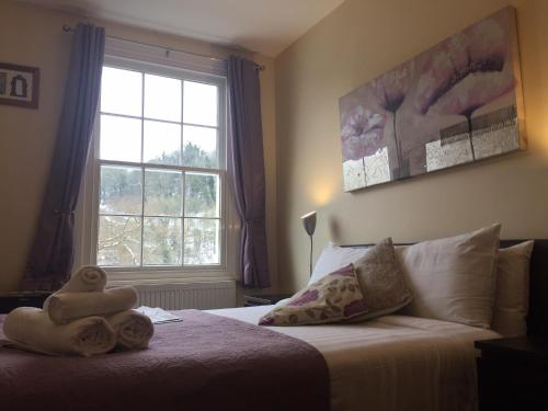 a bedroom with a bed with towels on it at Bridge View Guest House in Ironbridge