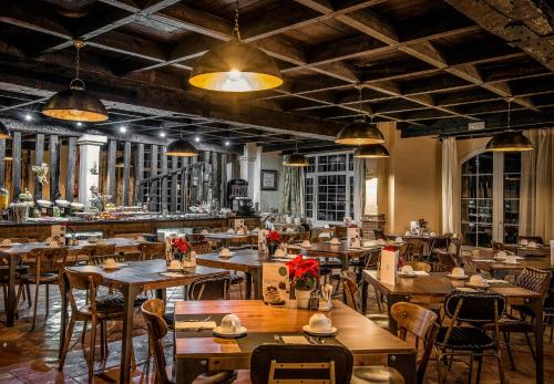 Un restaurante con mesas y sillas de madera y luces. en Vincci Selección Rumaykiyya, en Sierra Nevada