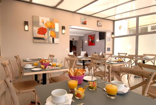 un restaurant avec des tables et des chaises avec de la nourriture dessus dans l'établissement Le Maray, au Grau-du-Roi