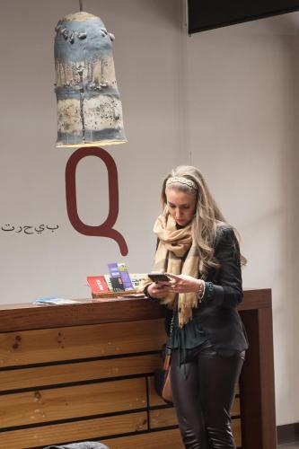 a woman standing next to a table looking at her cell phone at Casa Q in Quito