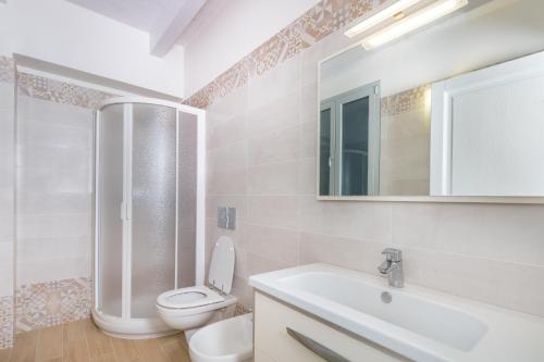 a bathroom with a toilet and a sink and a mirror at Appartamento Costa del Sole in Pomonte