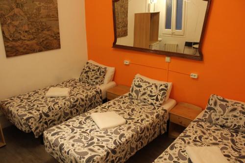 a small room with two beds and a mirror at Pensión Arosa in Barcelona