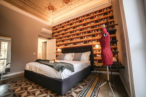 a bedroom with a bed with a red stuffed animal on the wall at Family Affair Luxury Rooms&Suites in Palermo