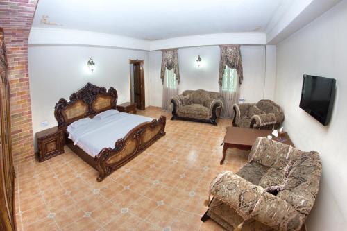 a bedroom with a bed and a couch and chairs at Venezia Palazzo Hotel in Yerevan