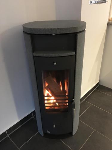 a black stove with a fire in a room at Ferienhaus am Kreuzberg - Nürburgring in Ulmen