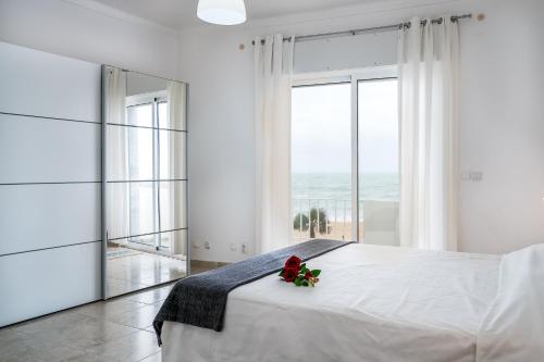 奎特里拉的住宿－T2 Avenida- Frente Mar, Ar-Condicionado, Wifi，白色的卧室,床上有花
