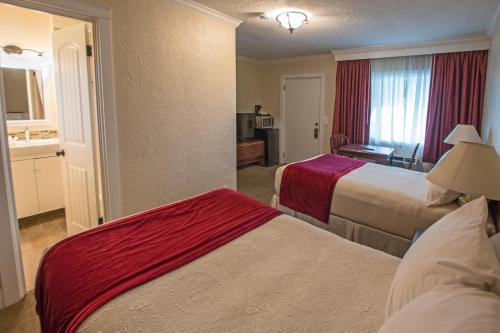 a hotel room with two beds and a bathroom at Auld Holland Inn in Oak Harbor