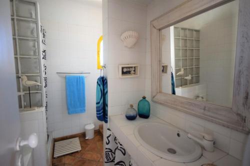 La salle de bains est pourvue d'un lavabo et d'un miroir. dans l'établissement V2 Aldeia Do Golf- Piscina, Familiar, Aconchegante, à Vilamoura