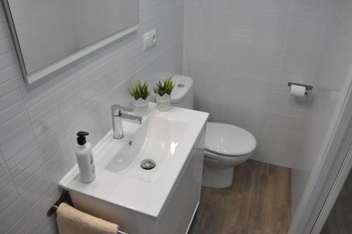 a white bathroom with a sink and a toilet at La Casita De Angela in Frigiliana