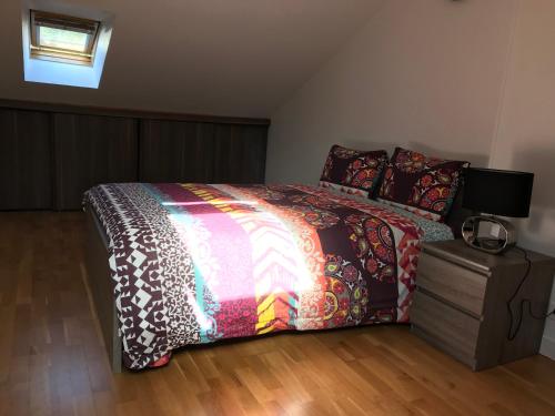 Un dormitorio con una cama con un edredón colorido. en Appartement Rue Victor Hugo - Port de la Houle, en Cancale