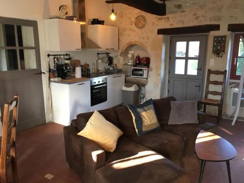 un salon avec un canapé et une cuisine dans l'établissement Gîte des Cochards, à Seigy