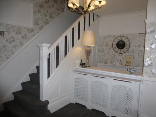 a stairwell with a white staircase with a lamp at The Kenmore Guest House in Llandudno