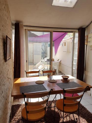 une salle à manger avec une table et des chaises et une fenêtre dans l'établissement Maison Arles, à Arles