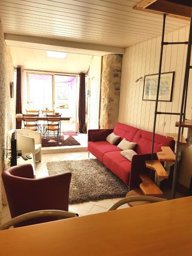 un salon avec un canapé rouge et une table dans l'établissement Maison Arles, à Arles