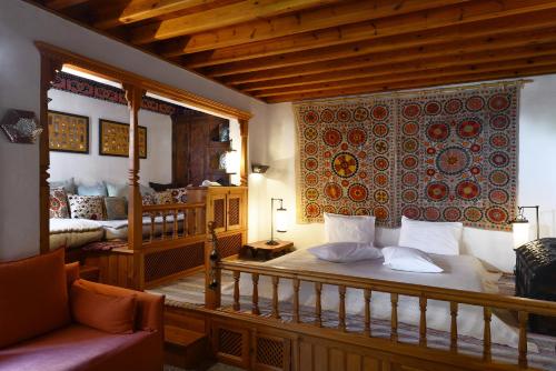 a bedroom with a bed and a couch in a room at Melenos Art Boutique Hotel in Líndos