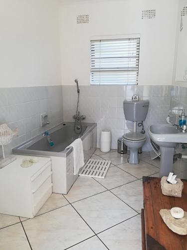a bathroom with a tub and a toilet and a sink at Lighthouse Accommodation in East London