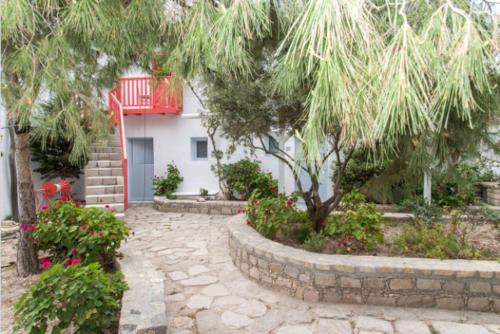 a tree in front of a house with a stone path at Thalassitra Private Pool Suites in Adamas