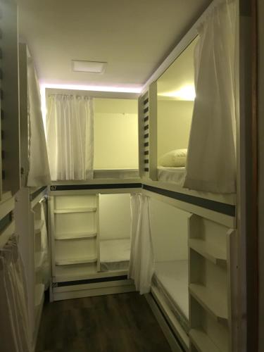 a walk in closet with white cabinets and shelves at AIPA HOSTEL.COM in Cabo Frio