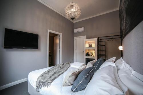 a bedroom with a bed with a television on the wall at Family Affair Luxury Rooms&Suites in Palermo