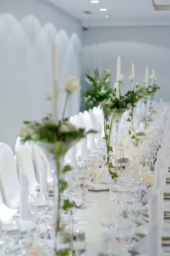 a long table with wine glasses and flowers on it at Villa Vanilla in Kędzierzyn-Koźle