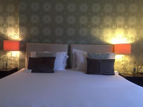 a bedroom with a large bed with two lamps at The Hambrough in Ventnor