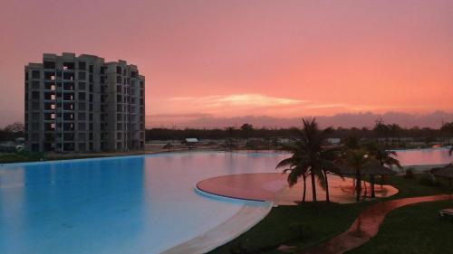 a large swimming pool in front of a tall building at Departamento en Dream Lagoons Cancun in Cancún
