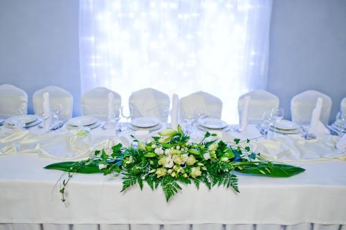 a white table with a bouquet of flowers on it at Villa Vanilla in Kędzierzyn-Koźle