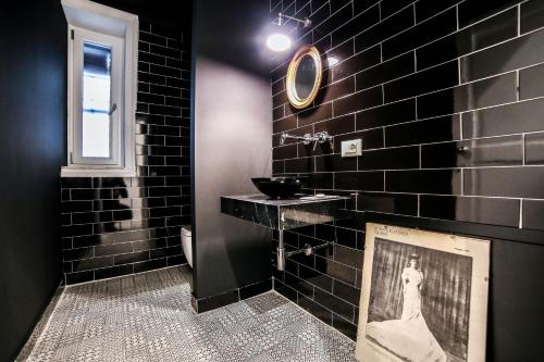 a black bathroom with a picture of a woman on the wall at Family Affair Luxury Rooms&Suites in Palermo