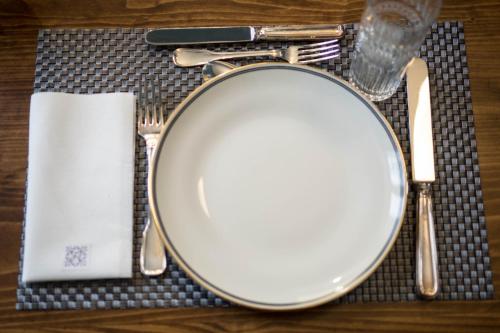 a table with a plate and utensils on a table at Family Affair Luxury Rooms&Suites in Palermo