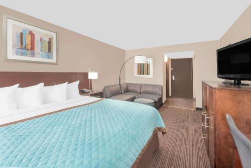 a hotel room with a bed and a flat screen tv at Wyndham Garden Midland in Midland