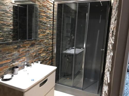 uma casa de banho com uma cabina de duche em vidro e um lavatório. em Maison PROVENCALE em Arles