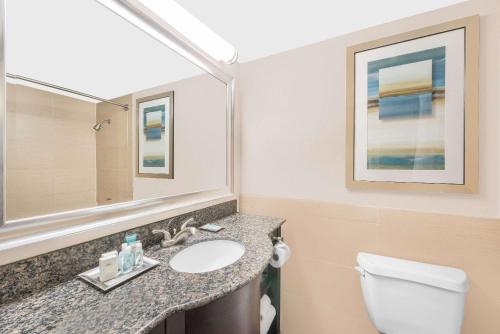 a bathroom with a sink and a toilet and a mirror at Wyndham Garden Midland in Midland