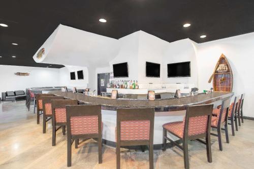 a bar in a room with a bunch of chairs at Wyndham Garden Midland in Midland