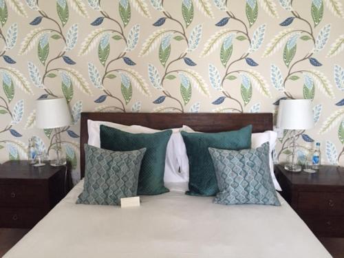 a bedroom with a bed with two lamps and a wallpaper at The Hambrough in Ventnor