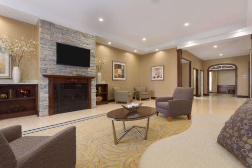 a living room with a fireplace and a tv at Wyndham Garden Grand Rapids Airport in Grand Rapids