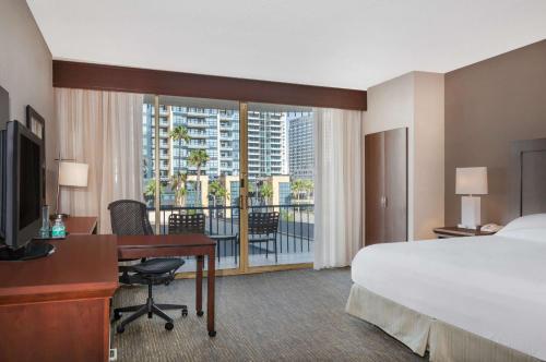 a hotel room with a bed and a desk and a bed and a window at Wyndham San Diego Bayside in San Diego