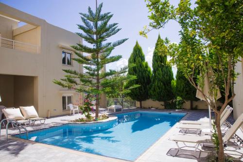 una piscina con un pino junto a un edificio en Home Skouloudi, en Dhrámia