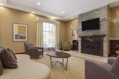 a living room with a fireplace and a tv at Wyndham Garden Grand Rapids Airport in Grand Rapids