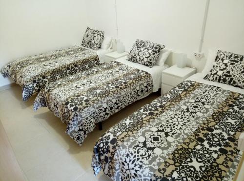 three beds and a couch in a room at Casa Carmen Barcelona in El Prat de Llobregat
